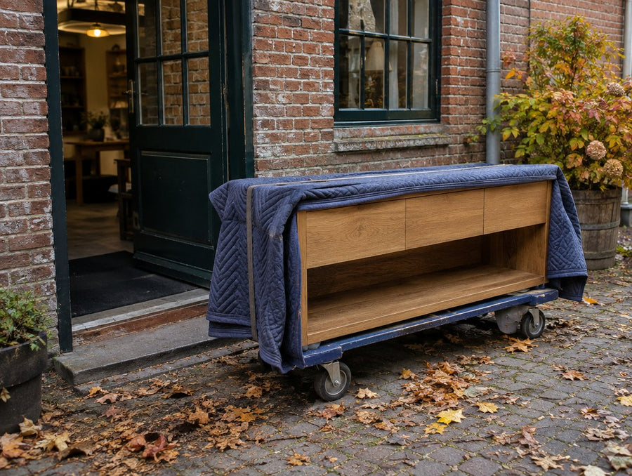A blanket-wrapped solid oak console at the back door of a historic brick shop